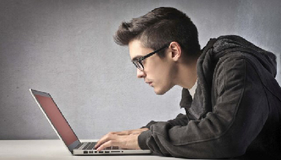 Человек в очках за компьютером